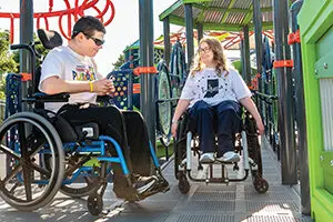Indiana Caverns - Bat Chaser Harrison county parks Possibility Playground in Corydon. Photo shows two teenagers in wheelchairs in playground area