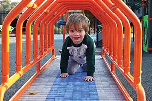 Indiana Caverns - Bat Chaser Small boy in rolling orange tunnel at Possibility Playground