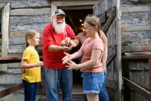 Family feeling ground corn outside Boone's Mill at Squire Boone Caverns