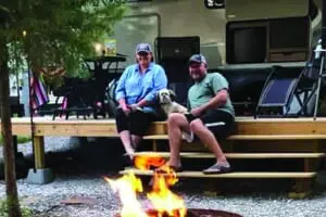 couple sitting on stairs around firepit
