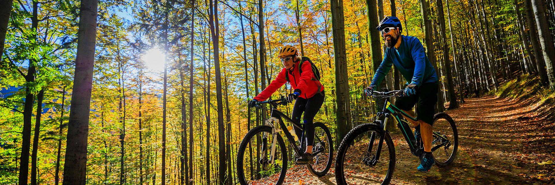 Cycling,Woman,And,Man,Riding,On,Bikes,At,Sunset,Mountains