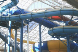 Looking up at giant slides and the glass panel ceiling at Big Splash Adventure