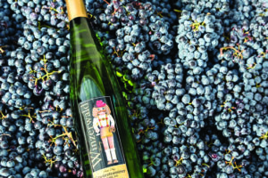 A bottle of Winzerwald wine on a bed of purple grapes