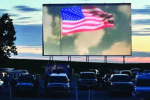 American Flag waving on the drive-in movie screen just before the movie begins