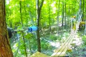 Person walking on swinging walkway between trees at SBC Zipline Adventure