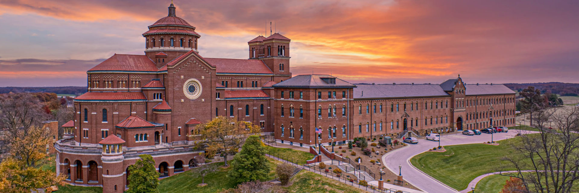 The Monastery Immaculate Conception shown on the beautiful hillside with a stunning sunset behind the building.