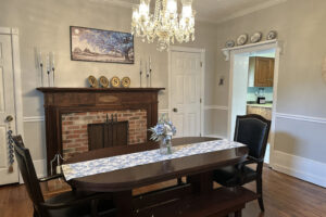 IMG_4518-Fixs Dining room at the Ross Mansion. Long narrow wooden table, fireplace, and chandelier.